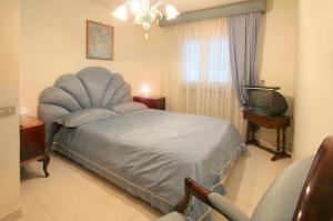 1 dormitorio con 1 cama azul y TV en Villa Cinzia en Sant'Agnello