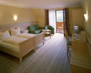 a bedroom with a bed and a living room at Gasthof Hofbauer in Breitenau am Hochlantsch