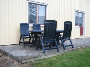 four black chairs and a table on a deck at Ulricehamn Nilsagården in Ulricehamn