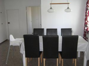 a dining room table with black chairs and a white table at Ulricehamn Nilsagården in Ulricehamn