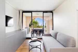 a living room with a couch and a table at Suite 118 - Piscine - 50 Metres Plage - Terrasse - Clim - Wifi in Cannes