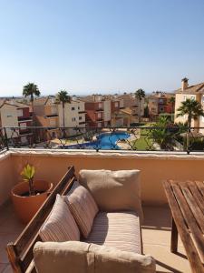 a couch on a balcony with a view of a playground at Dúplex Águeda Altaona Golf in Murcia
