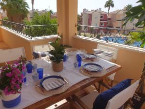una mesa en un balcón con vistas a la piscina en Increíble Duplex 2 plantas vistas piscina Altaona Golf -Mosa, en Murcia