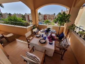 a room with a table and chairs on a balcony at Increíble Duplex 2 plantas vistas piscina Altaona Golf -Mosa in Murcia