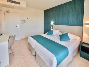 a hotel room with a large bed with blue pillows at BQ Belvedere Hotel in Palma de Mallorca