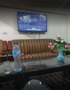 salon z kanapą i butelką wody na stole w obiekcie Arcadian Inn Hotel w mieście Gilgit