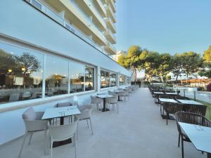 an empty restaurant with tables and chairs and windows at BQ Belvedere Hotel in Palma de Mallorca