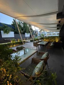 an outdoor patio with chairs and tables under a tent at LCH Fitness in Indore