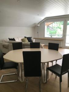ein Wohnzimmer mit einem Tisch, Stühlen und einem Sofa in der Unterkunft Gauenpark AL77 Wohnung Hutter in Flumserberg