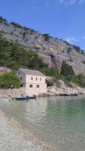 a building on the shore of a body of water at Apartmani Bepin in Selca kod Bogomolja