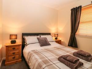 a bedroom with a bed with two towels on it at Harbour View in Buckie