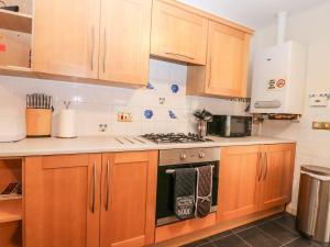 a kitchen with wooden cabinets and a stove top oven at Harbour View in Buckie