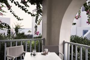 a table and chairs on a balcony with a view of the ocean at Poseidon of Paros Hotel & Spa in Chrissi Akti