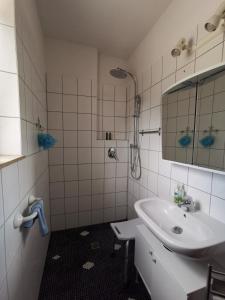 bagno bianco con lavandino e specchio di Tolles Möbliertes Zimmer in WG Haus in Ulm nähe Uni und Uni-Klinik a Ulma