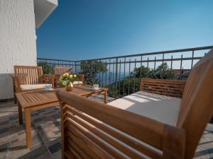 a balcony with a bed and chairs and the ocean at Villa Tranquila in Budva