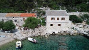 an aerial view of a house and boats in the water at Apartmani Bepin in Selca kod Bogomolja