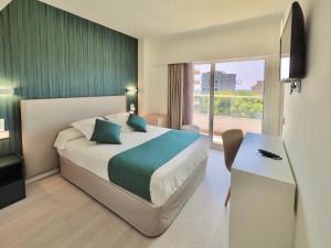a hotel room with a bed and a desk and a window at BQ Belvedere Hotel in Palma de Mallorca