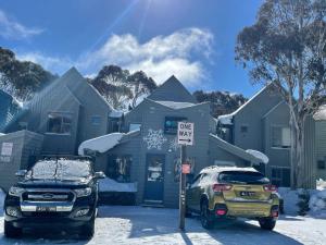 two cars parked in front of a house in the snow at Snow Gums 16, alpine-getaways in Dinner Plain