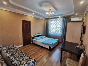a bedroom with a bed and a table and a window at Hotel Milana in Orenburg