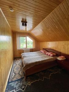 - une chambre avec un lit dans une pièce en bois dans l'établissement Криївка у ставка, à Berkhomet-pe-Siret
