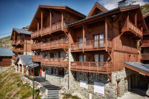 un gran edificio de madera con balcones. en Les Chalets de Rosael - Val Thorens, en Val Thorens