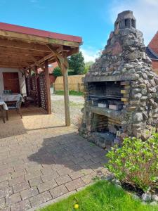 a stone fireplace in a yard next to a patio at Ferienhaus Loose in Loose
