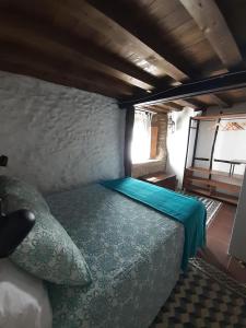 ein kleines Schlafzimmer mit einem Bett in einem Zimmer in der Unterkunft HERVÀS Y VUELVES ( la casita de la piedra ) in Hervás
