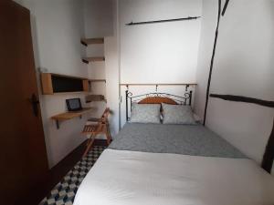 ein Schlafzimmer mit einem Bett in einem kleinen Zimmer in der Unterkunft HERVÀS Y VUELVES ( la casita de la piedra ) in Hervás