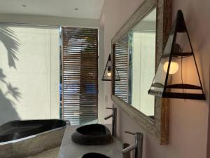 a bathroom with a sink and a mirror and a tub at Villa Sassy in Seminyak