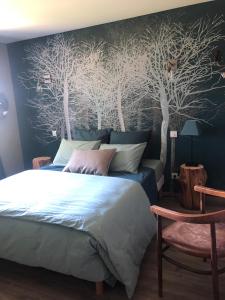 - une chambre avec un lit et une fresque murale sur les arbres dans l'établissement La Gatille, à Villié-Morgon
