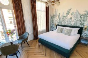 - une chambre avec un lit, une table et des chaises dans l'établissement Hotel Sebel, à La Haye