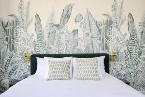 ein Schlafzimmer mit einem Bett mit einer tropischen Tapete in der Unterkunft Hotel Sebel in Den Haag