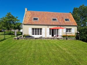 ein Haus mit einem großen Garten davor in der Unterkunft La petite chouette in Saint-Côme-de-Fresné