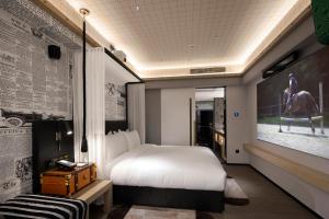 a hotel room with a bed and a painting on the wall at Arthur Hotel Canton Tower Guangzhou-广州塔骑士物语酒店 in Guangzhou
