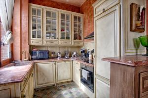 - une cuisine avec des placards en bois et un comptoir dans l'établissement CMG - Duplex de standing au coeur de Deauville - 7P - Terrasse, à Deauville