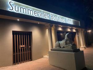 a building with a statue in front of a store at Summerview Boutique Hotel & Conference in Johannesburg