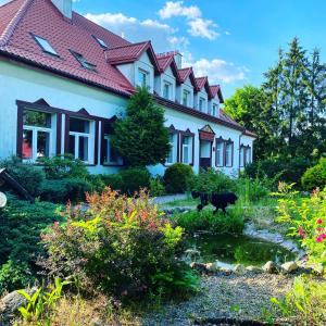 Uma casa com uma vaca à frente. em Gościnec pod lipami em Kruszyniany