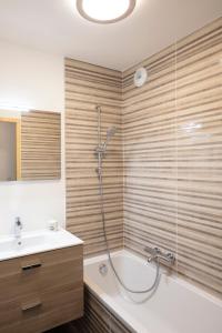 een badkamer met een douche, een bad en een wastafel bij TERRESENS - Les 3 Sophie in Morzine