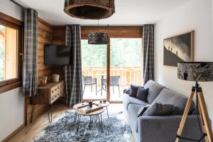 ein Wohnzimmer mit einem Sofa und einem Tisch in der Unterkunft TERRESENS - Les 3 Sophie in Morzine