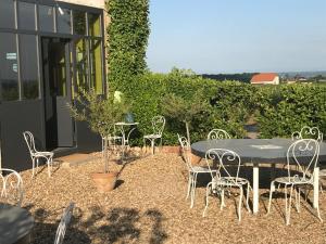 a patio with a table and chairs in front of a building at La Gatille in Villié-Morgon