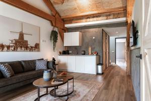 a living room with a couch and a table at Dutchen Erfgoedpark De Hoop Glamping, Appartementen & Cottages in Uitgeest +152 photos