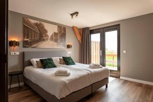a bedroom with a large bed and a large window at Dutchen Erfgoedpark De Hoop Glamping, Appartementen & Cottages in Uitgeest