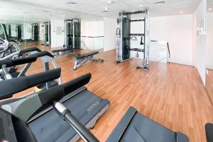 a gym with several treadmills and exercise machines at Cozy Studio at Dubai Water Canal next to Downtown in Dubai
