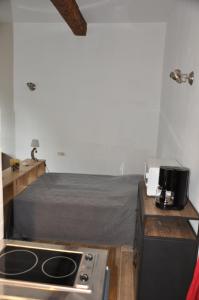 Habitación con cama y cocina con fogones. en location studio meublé avec jardin, en Sorgues