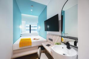 a small bedroom with a bed and a sink at Furama RiverFront in Singapore