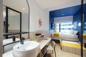 ein Bad mit einem Waschbecken und einem Bett in der Unterkunft Furama RiverFront in Singapur