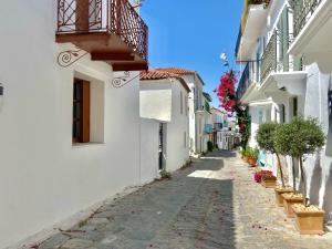 a narrow alley with white buildings and a balcony at Raphael Skiathos Living-Olga in Skiathos