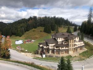 a large house on top of a hill with trees at Апартамент Пампорово Палас - Pamporovo Palace in Pamporovo