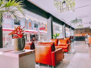 a restaurant with orange chairs and a potted plant at C & N Hotel Patong, Phuket in Patong Beach