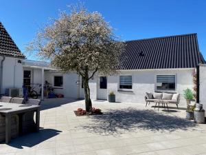 un árbol frente a una casa con patio en Motel Hune Apartments en Blokhus